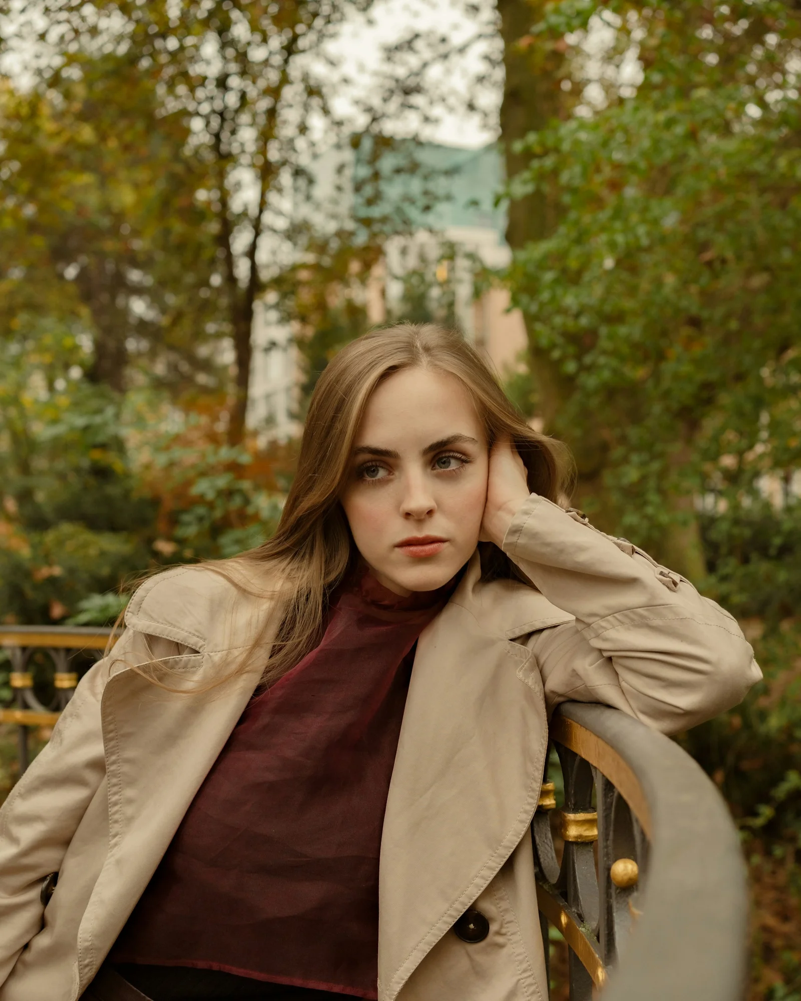 A woman is sitting in a park, looking pensive