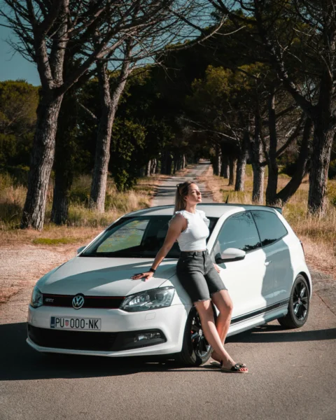 a woman sitting on the hood of a white car