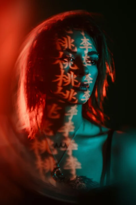 Woman's face is illuminated by chinese characters