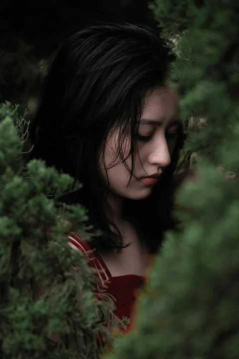 站在绿色植物旁的女子