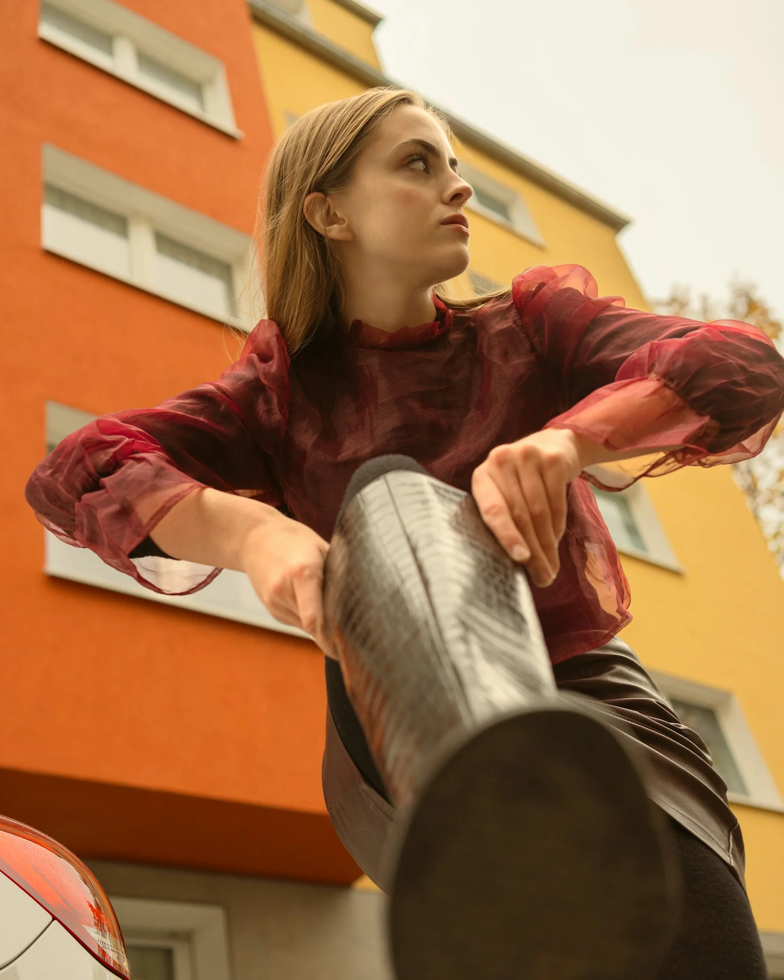A woman poses next to colorful apartment buildings