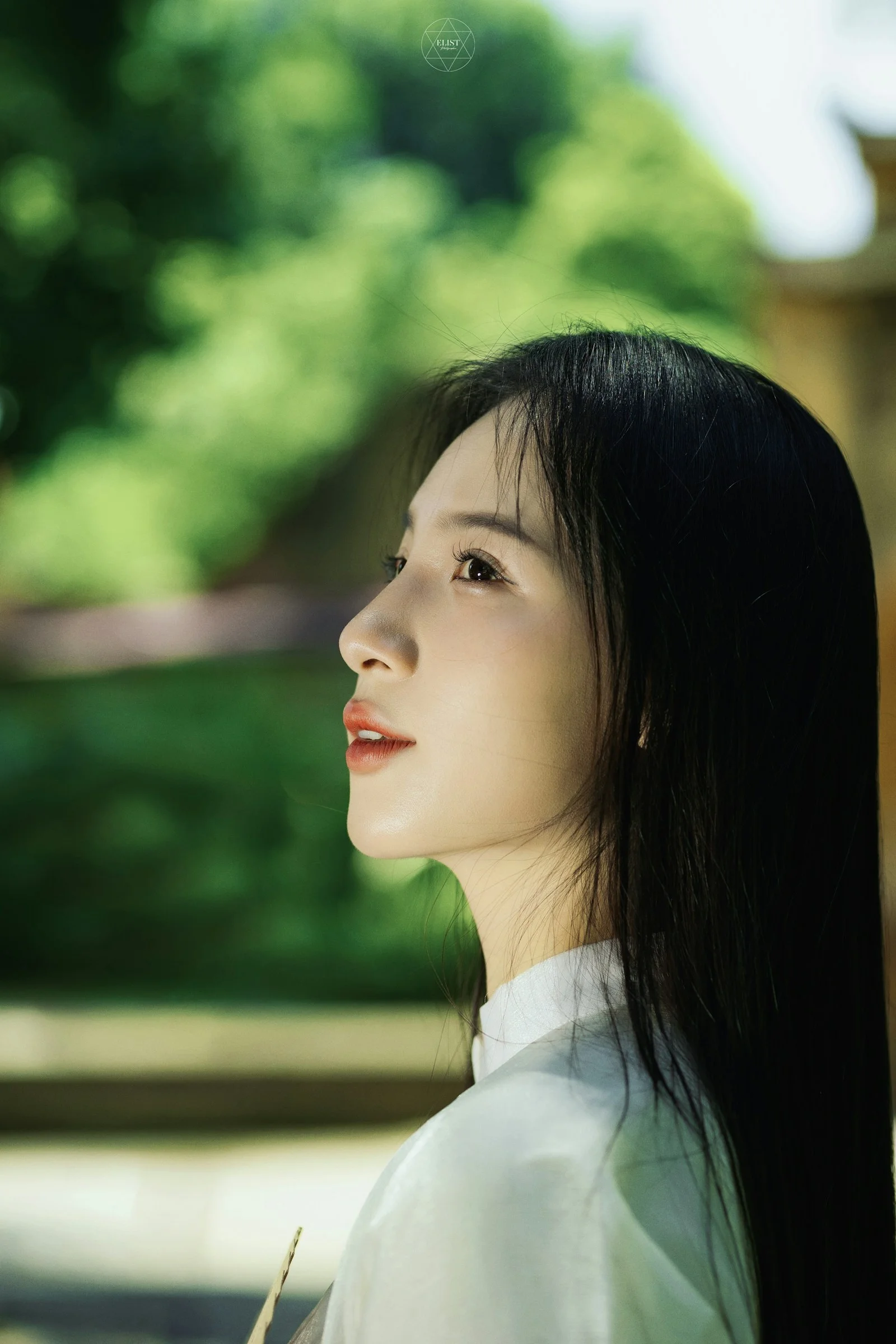 一位留着黑色长发、身穿白色衬衫的女子