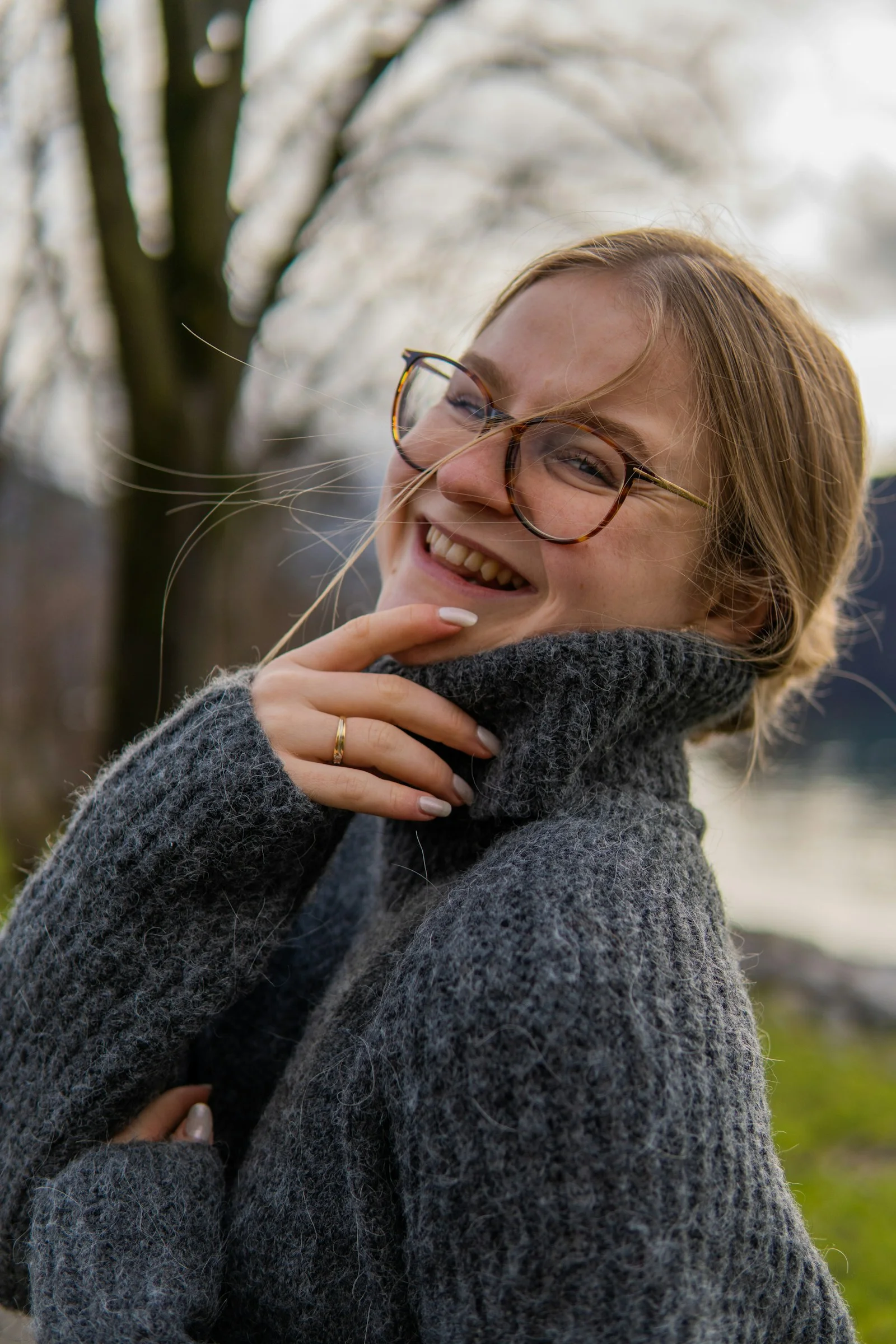a woman wearing glasses and a gray sweater