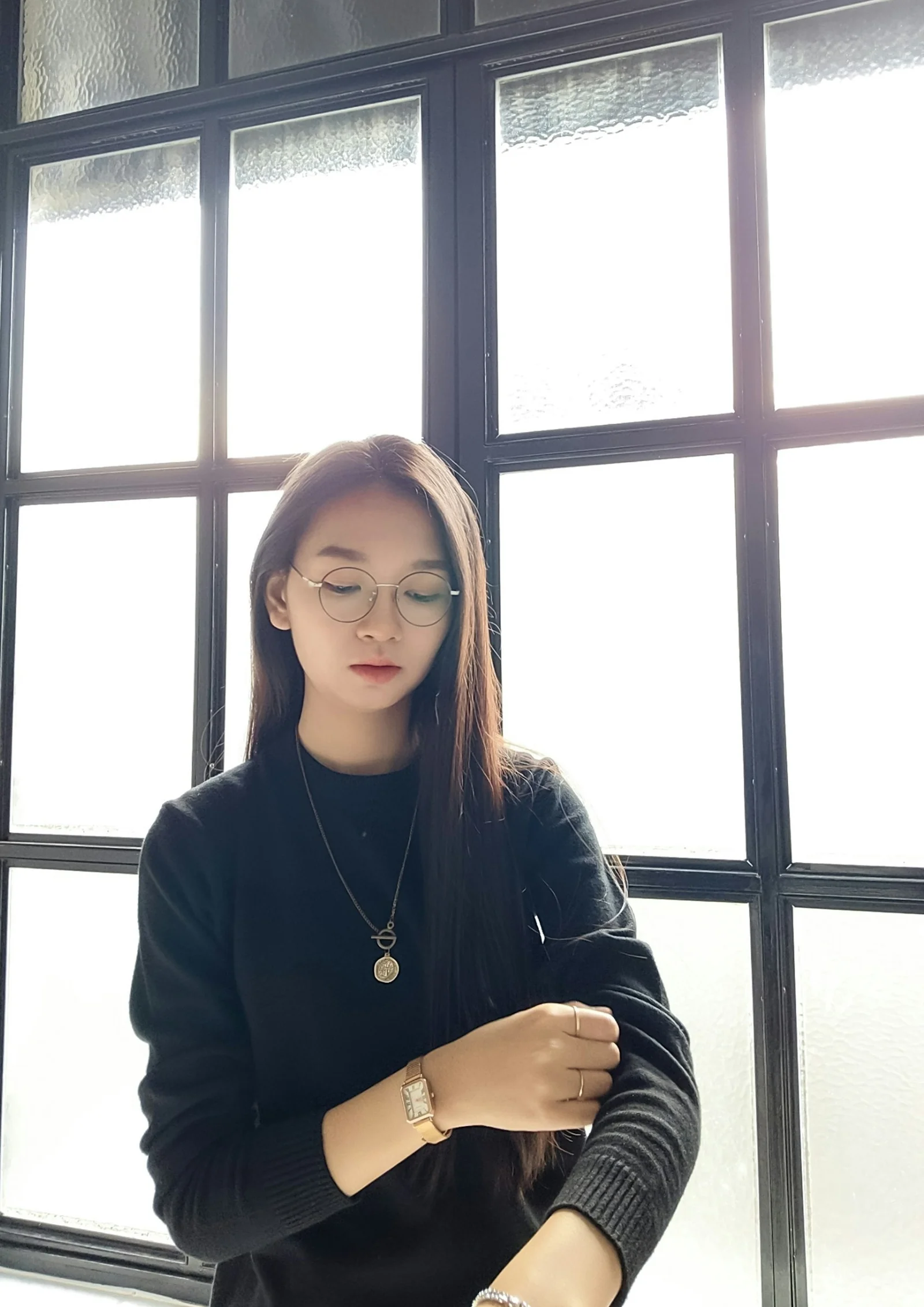 a woman wearing glasses looking at her cell phone