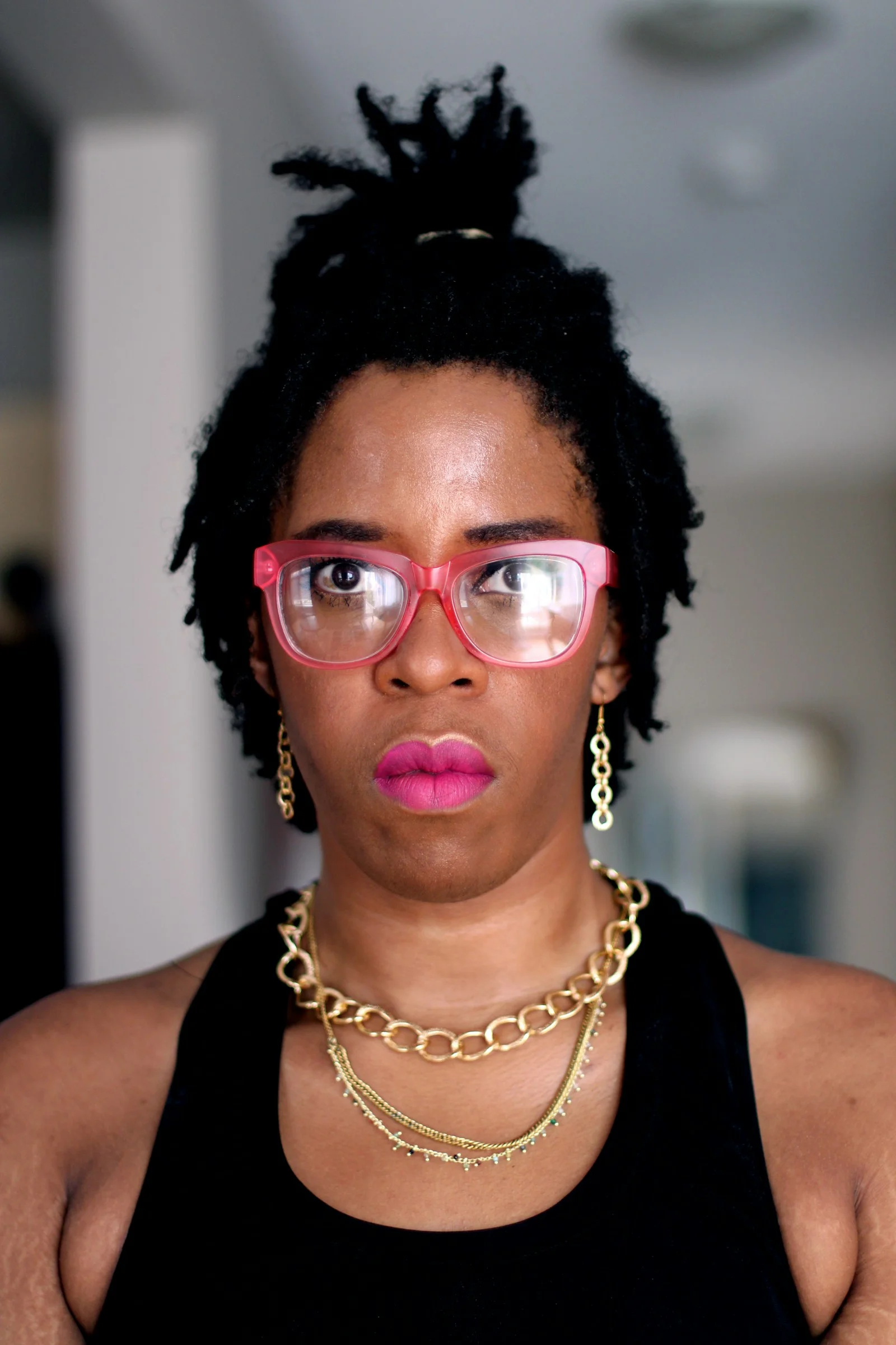 woman in black tank top wearing red framed eyeglasses