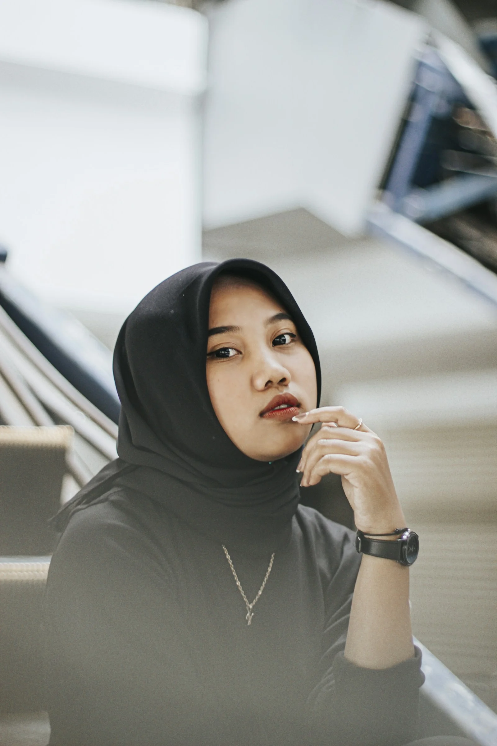 一名戴頭巾的女子坐在樓梯上
