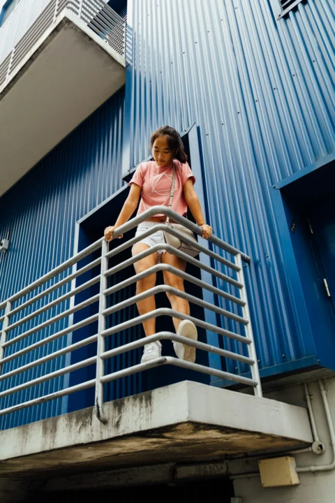 站在灰色栏杆上的女子