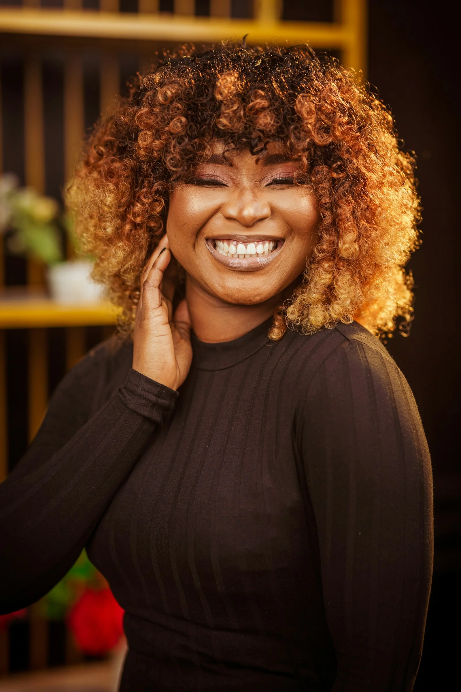 A woman smiles joyfully with beautiful curly hair