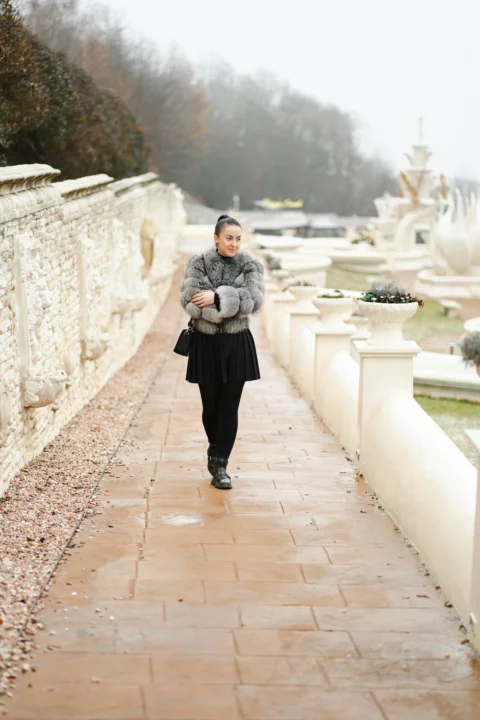 A woman walking down a walkway in a park