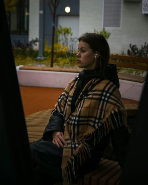 一位女子坐在户外的长椅上