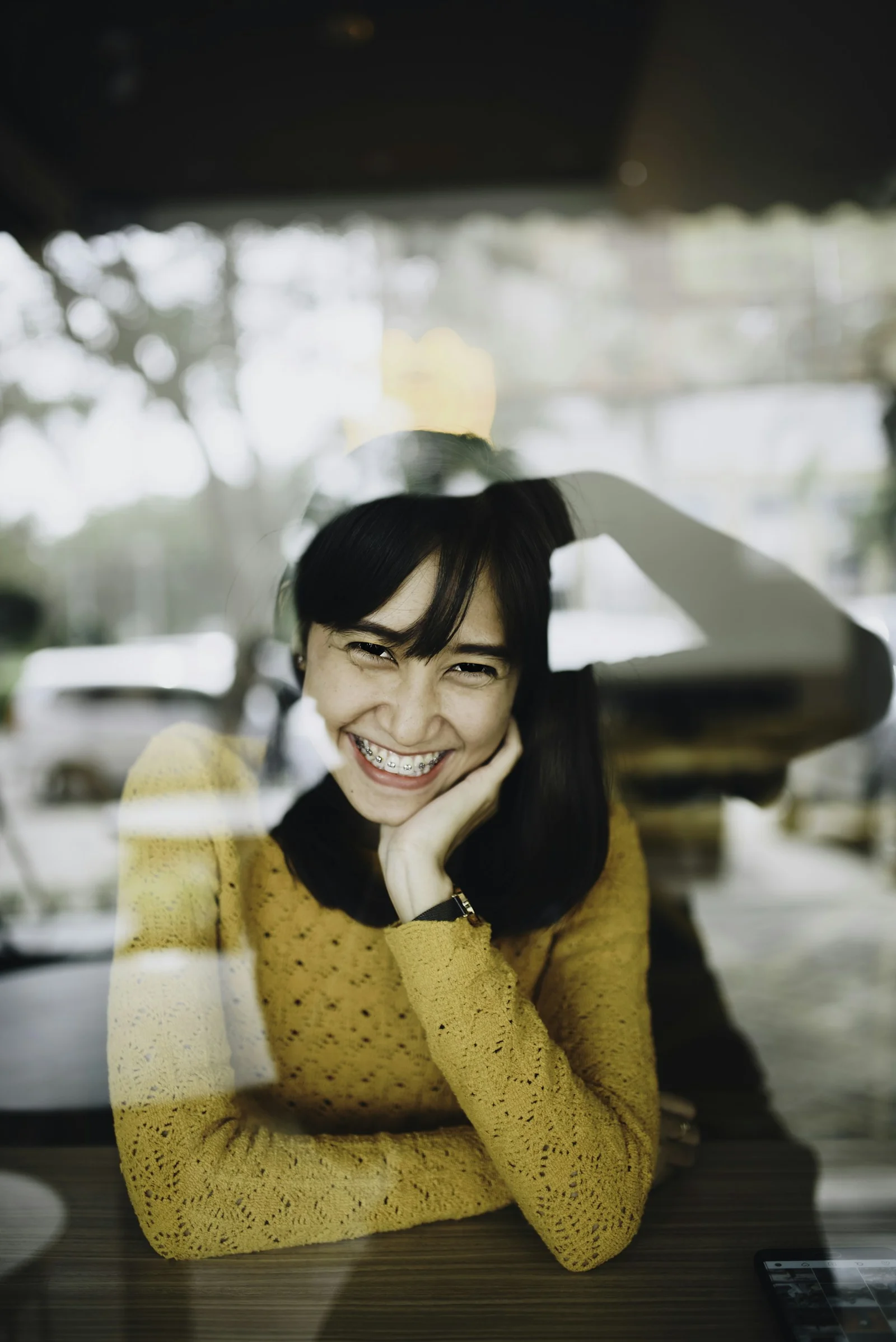 黄色いニットセーターを着て微笑む女性