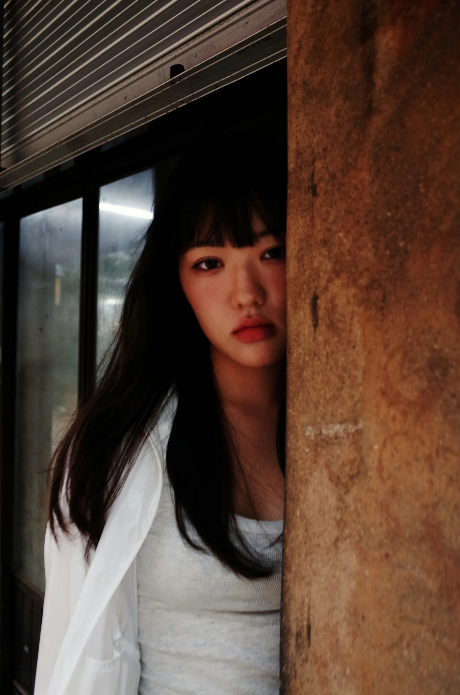 一个女人站在墙后看着镜头