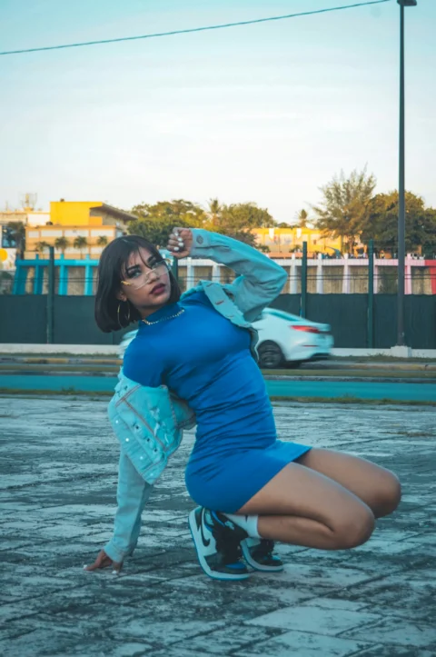a woman in a blue dress is kneeling down