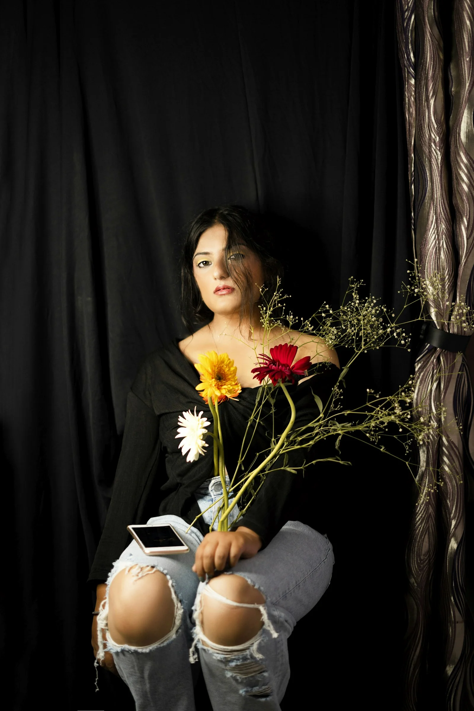 woman in black long sleeve shirt holding white and yellow flowers