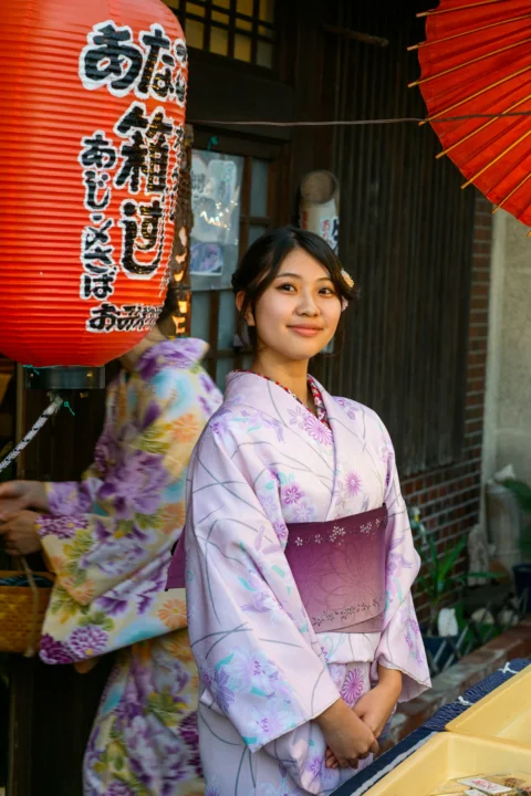 A woman in a kimono standing in front of a store