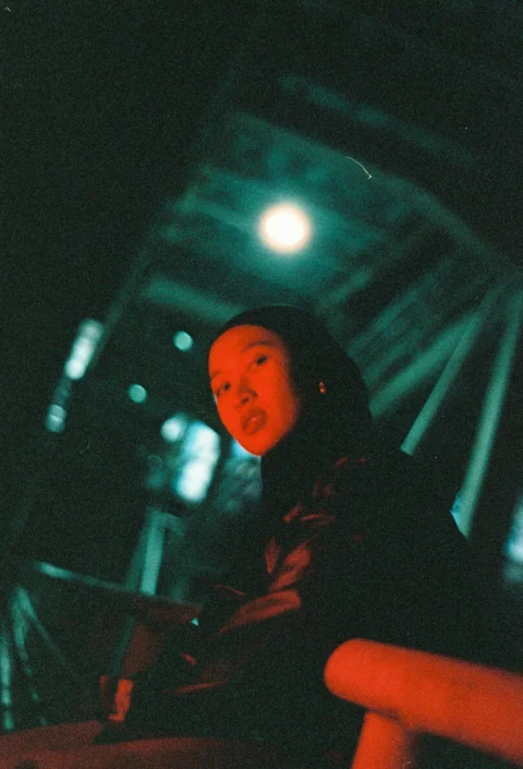 Woman under a bridge looks at the camera