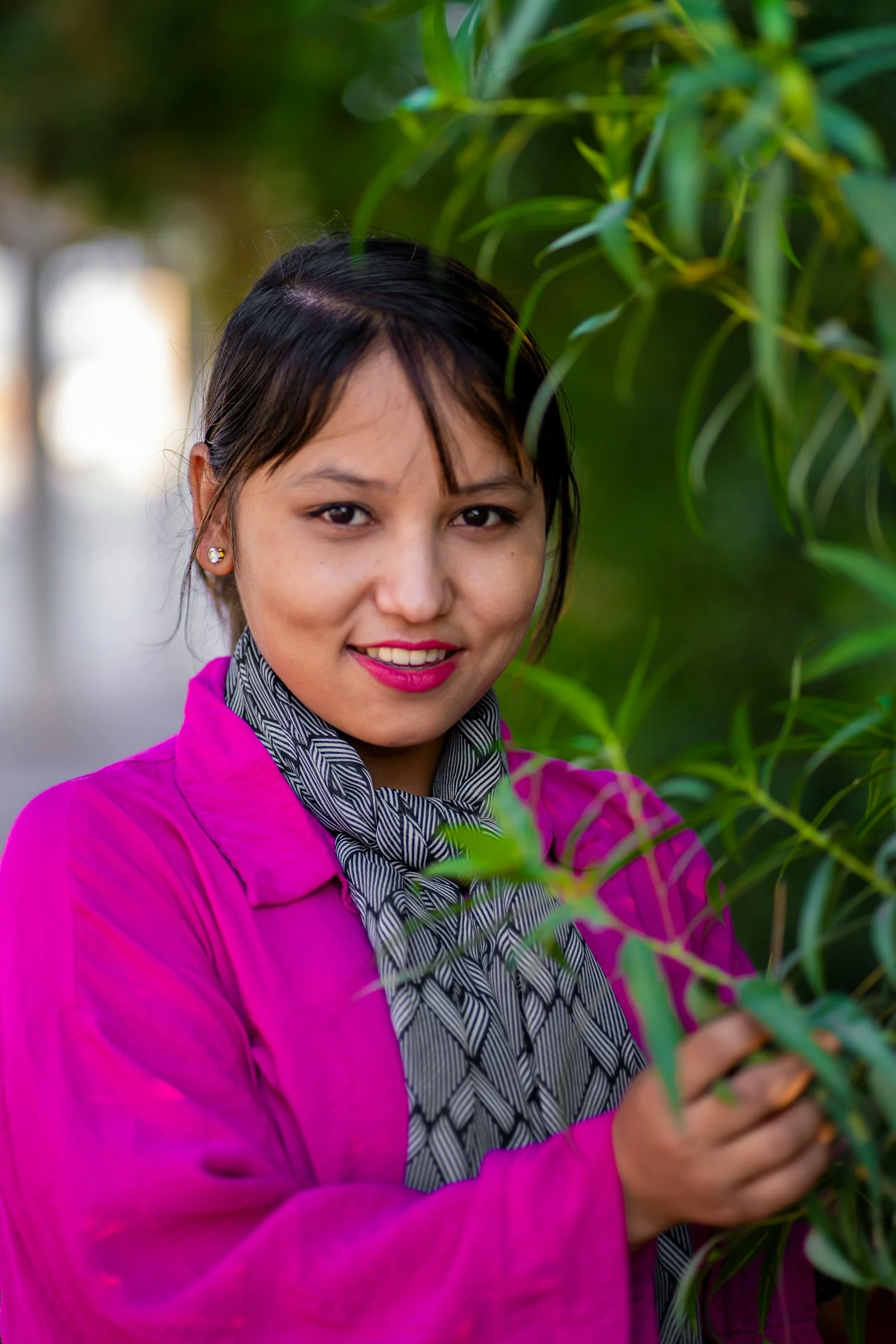 A woman standing next to a tree with a scarf on