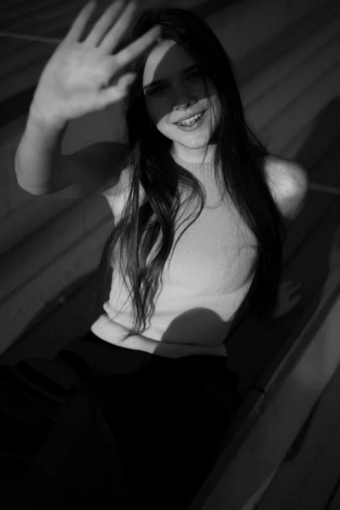 Smiling woman shields eyes from the sun
