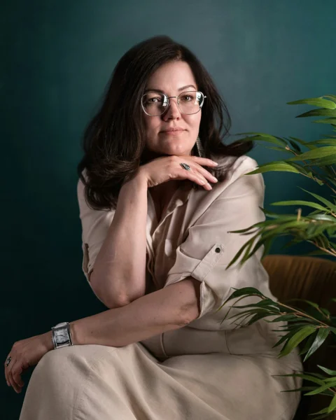 一名女子坐在椅子上,旁邊有一盆盆栽