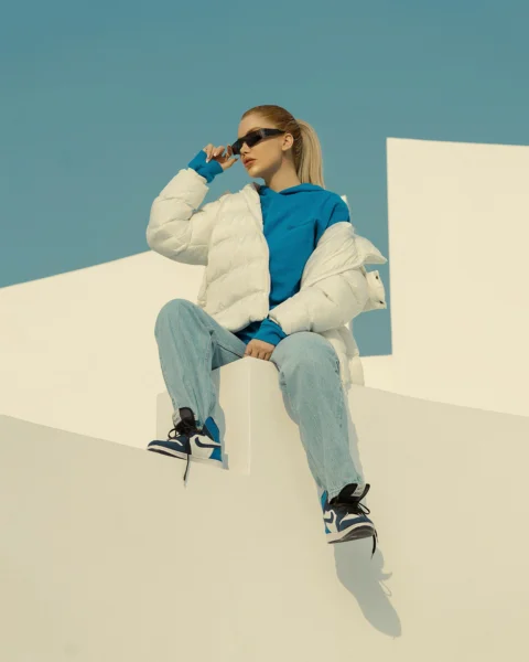 a woman sitting on top of a white wall