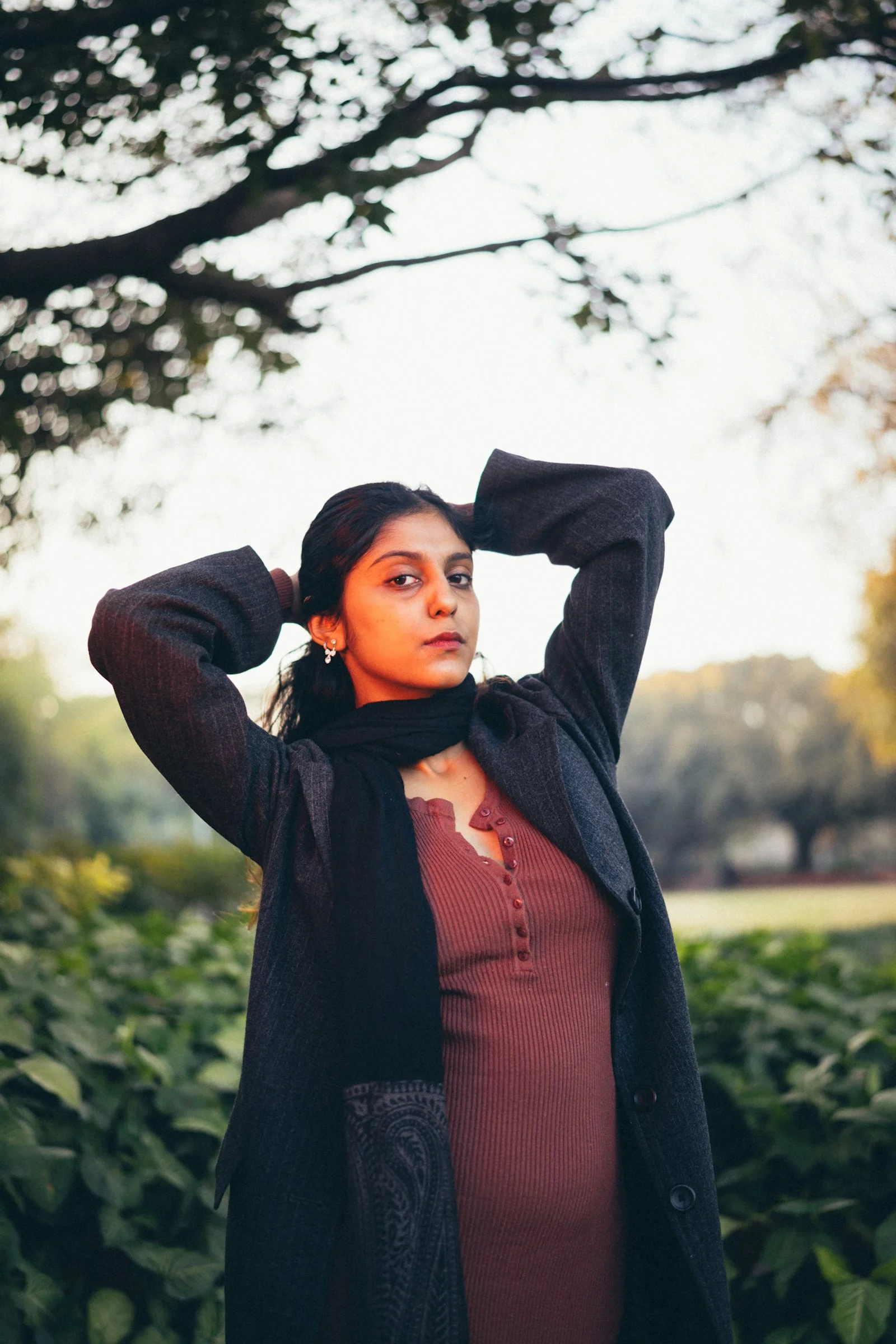Young woman with hands in hair outdoors