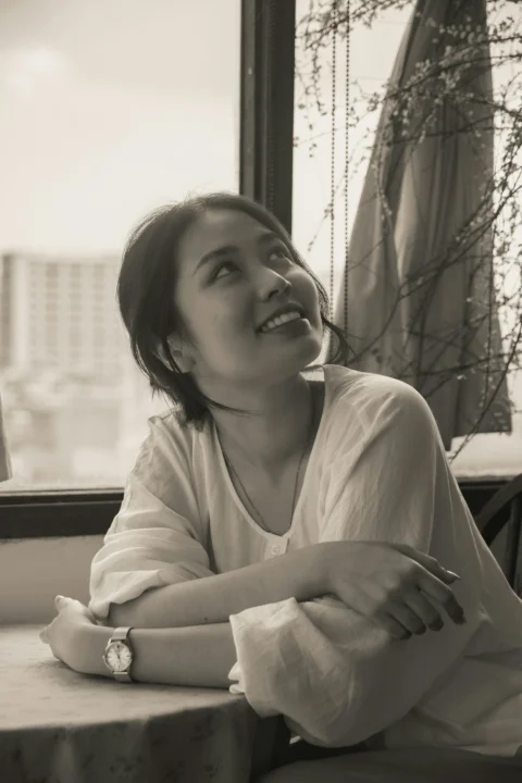 穿白衬衫仰头望向窗户的女人
