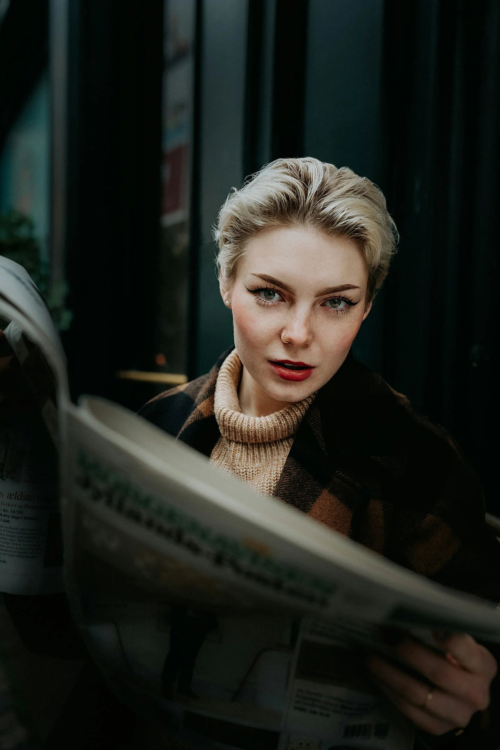 a woman is reading a newspaper outside