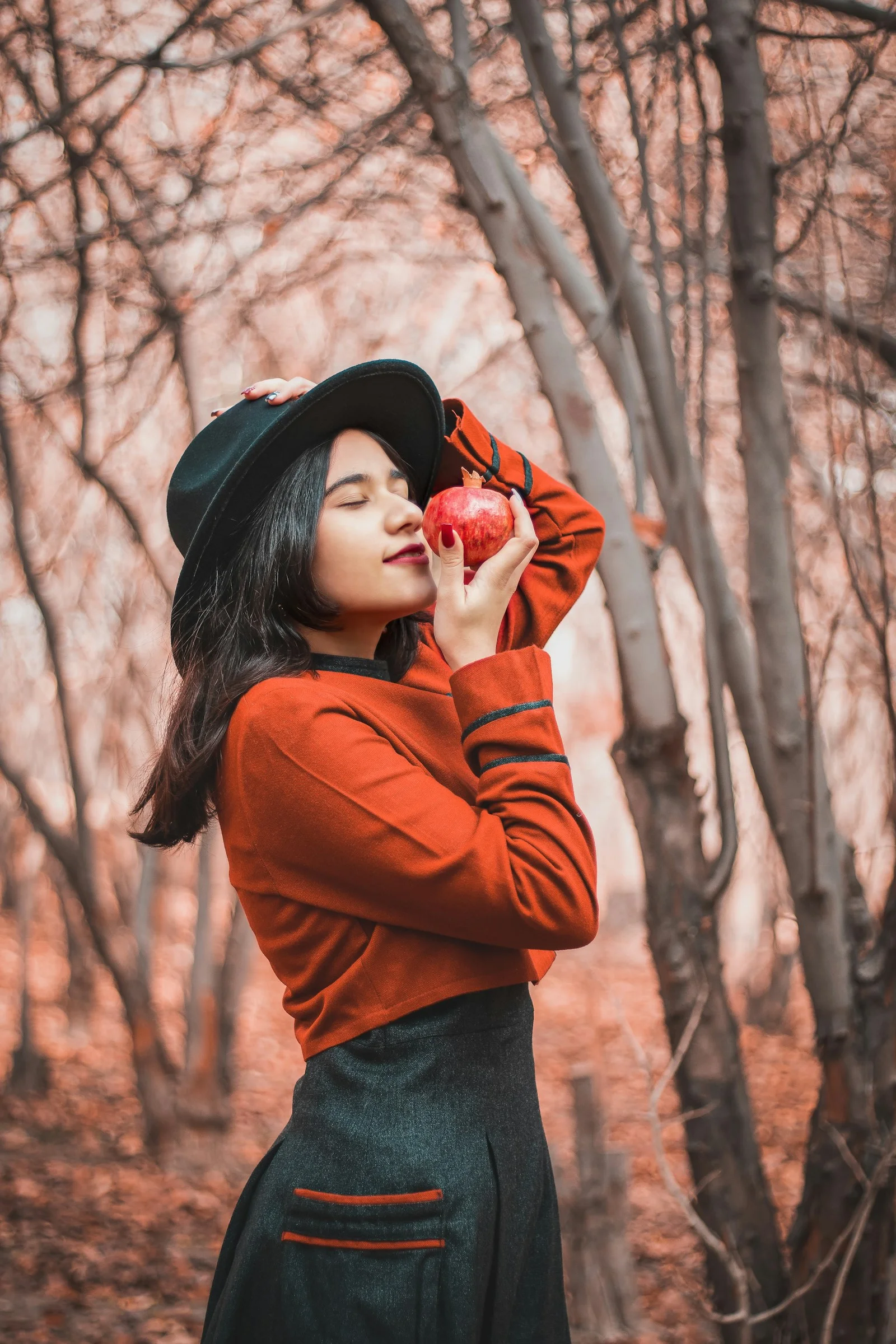 穿棕色長袖襯衫戴著黑色帽子的女子白天站在光禿的樹木旁