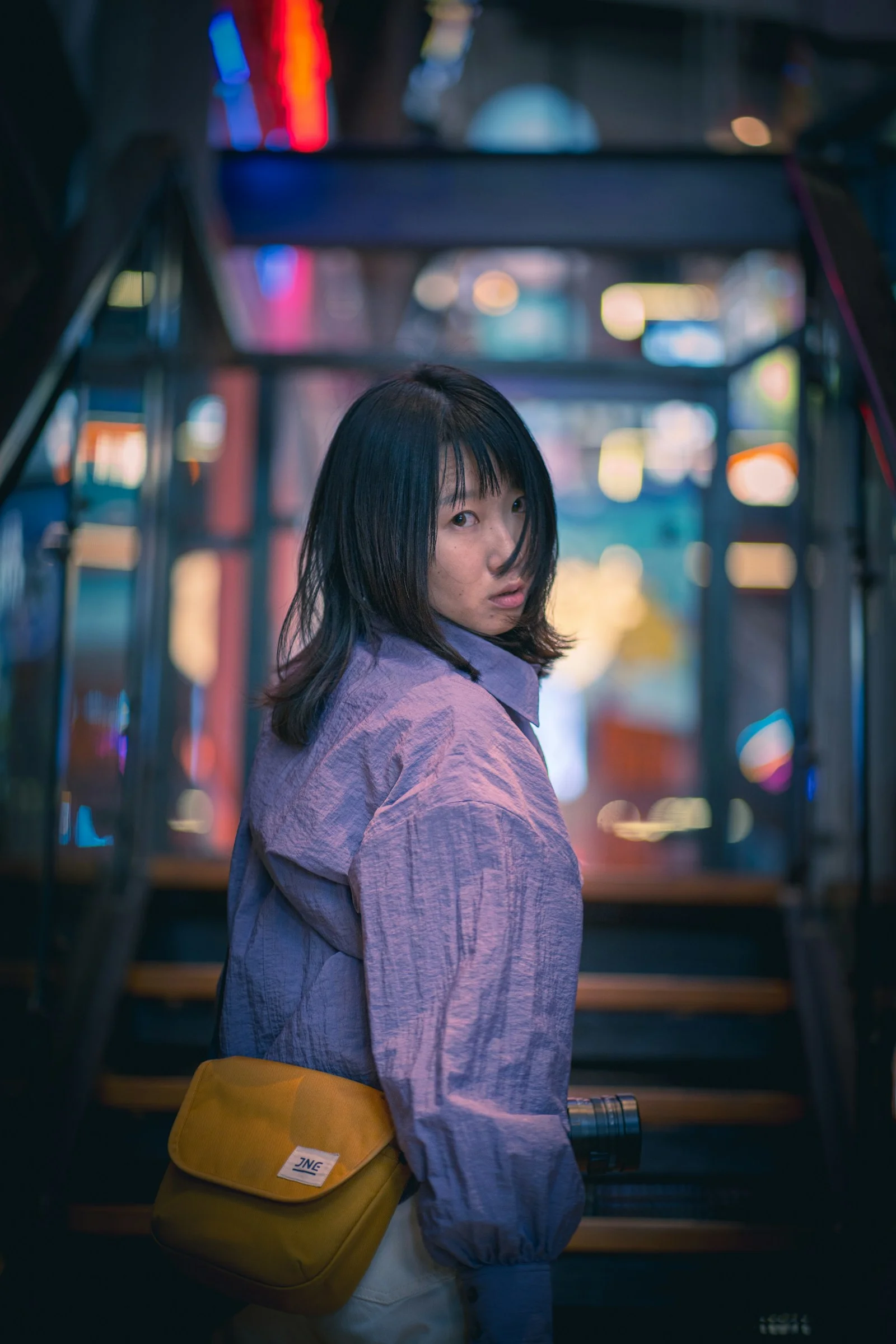 身穿紫色衬衫站在火车站的女孩