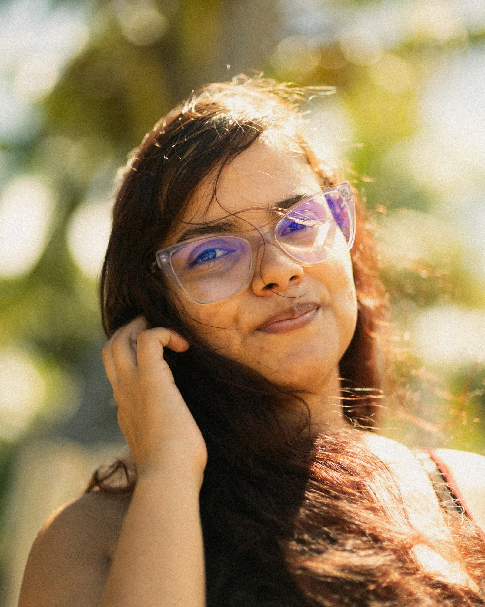 Smiling woman wearing clear glasses in natural light