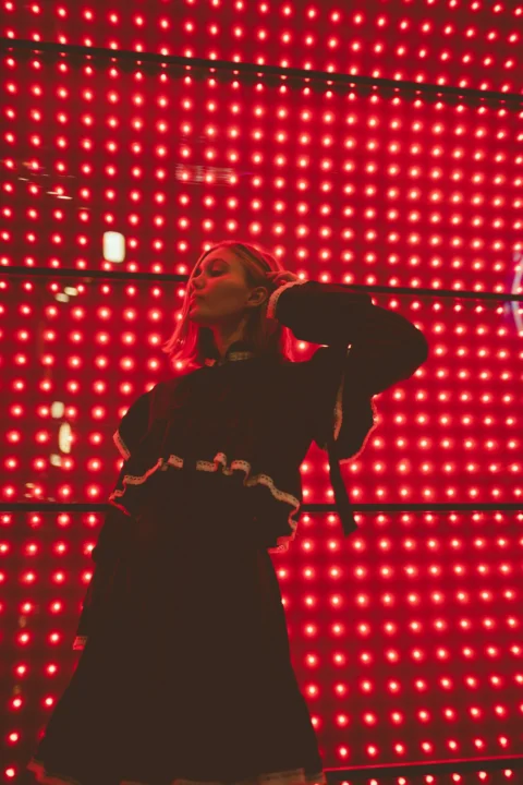 a woman standing in front of a red light
