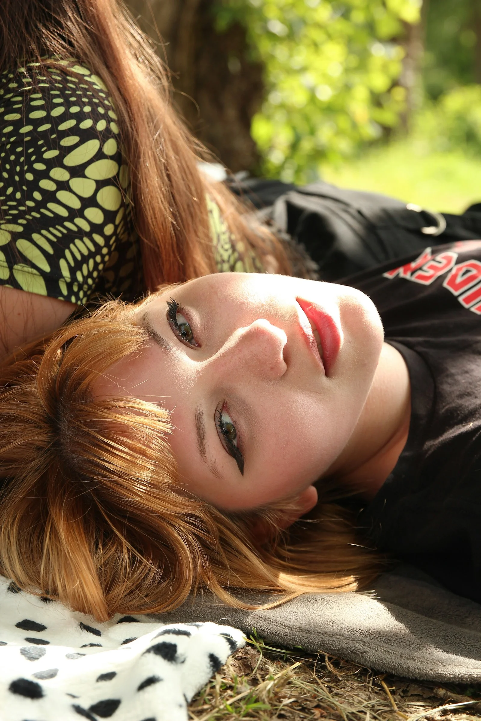 A woman laying on a blanket in the grass