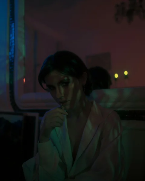 穿白色外套的女人站在窗边