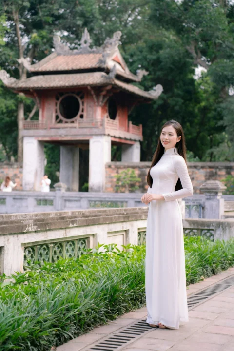 Woman in traditional attire poses near a temple