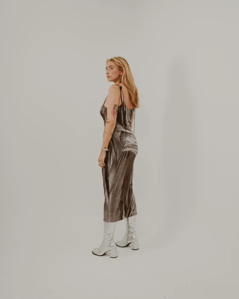 a woman in a brown dress and white boots