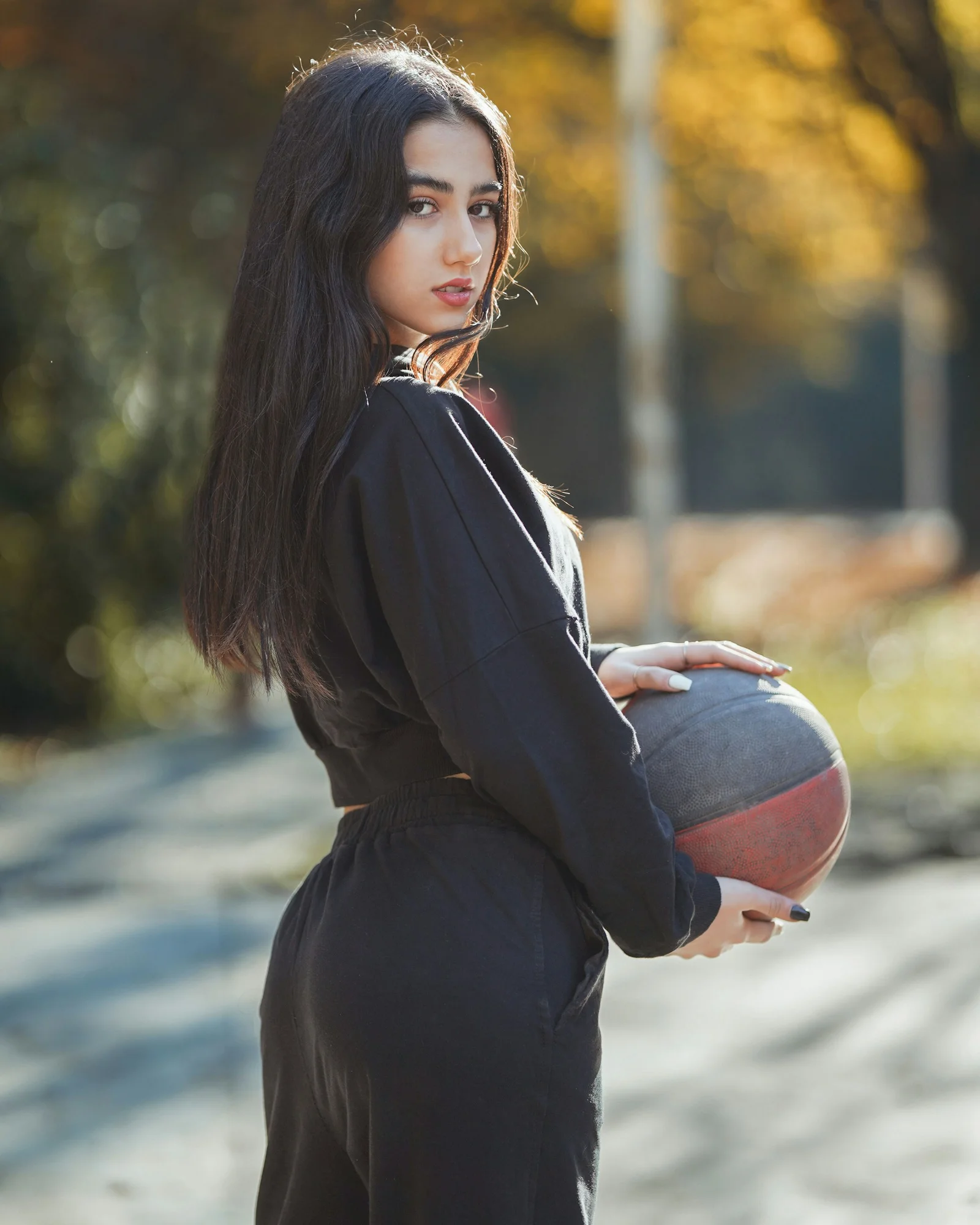 女性在戶外拿著籃球擺出姿勢