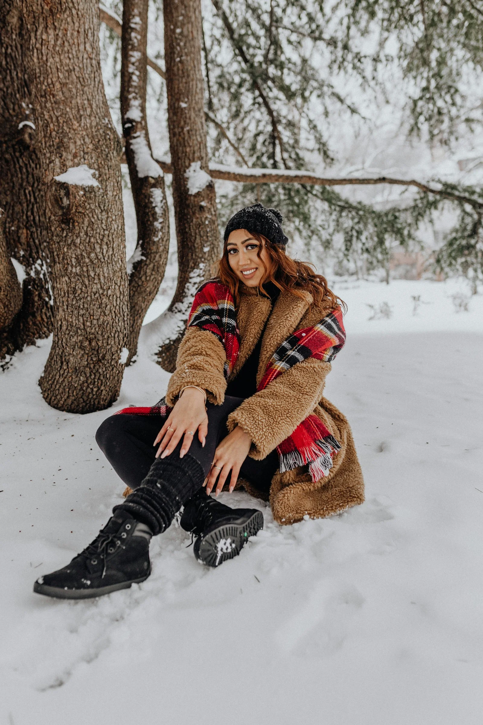 穿着靴子坐在雪地里的女子