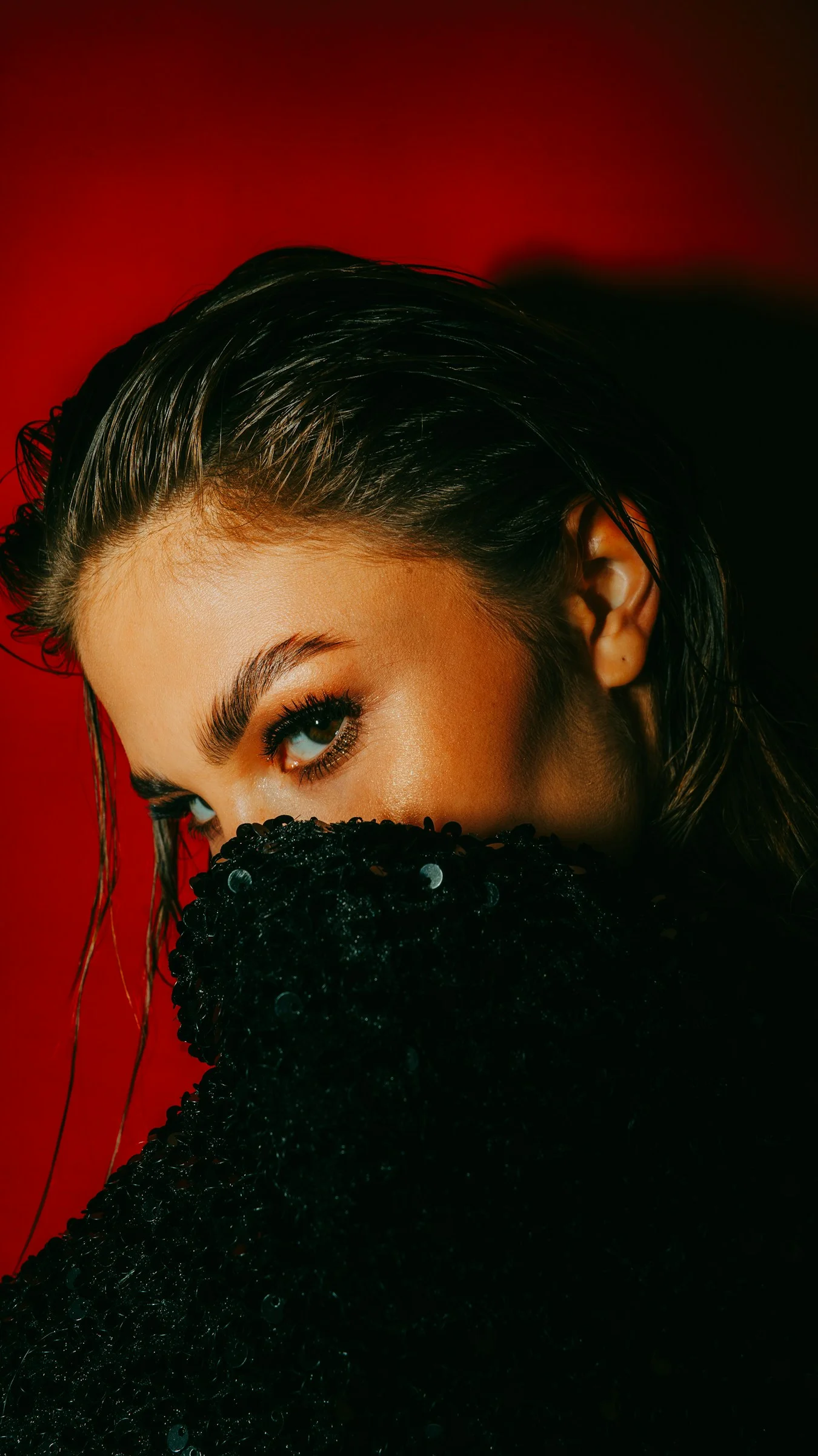 A woman with a black coat covering her face