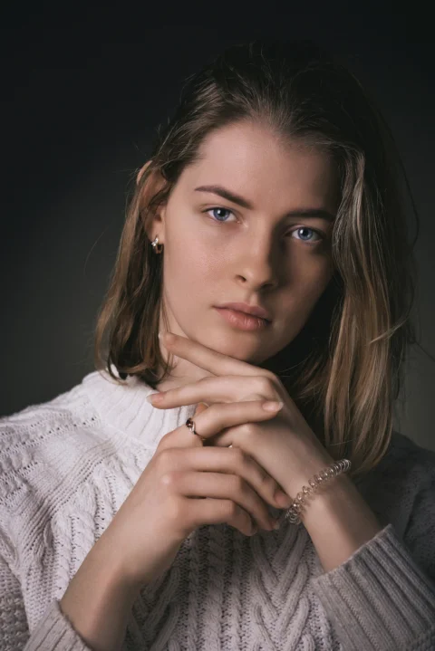 a woman in a white sweater posing for a picture