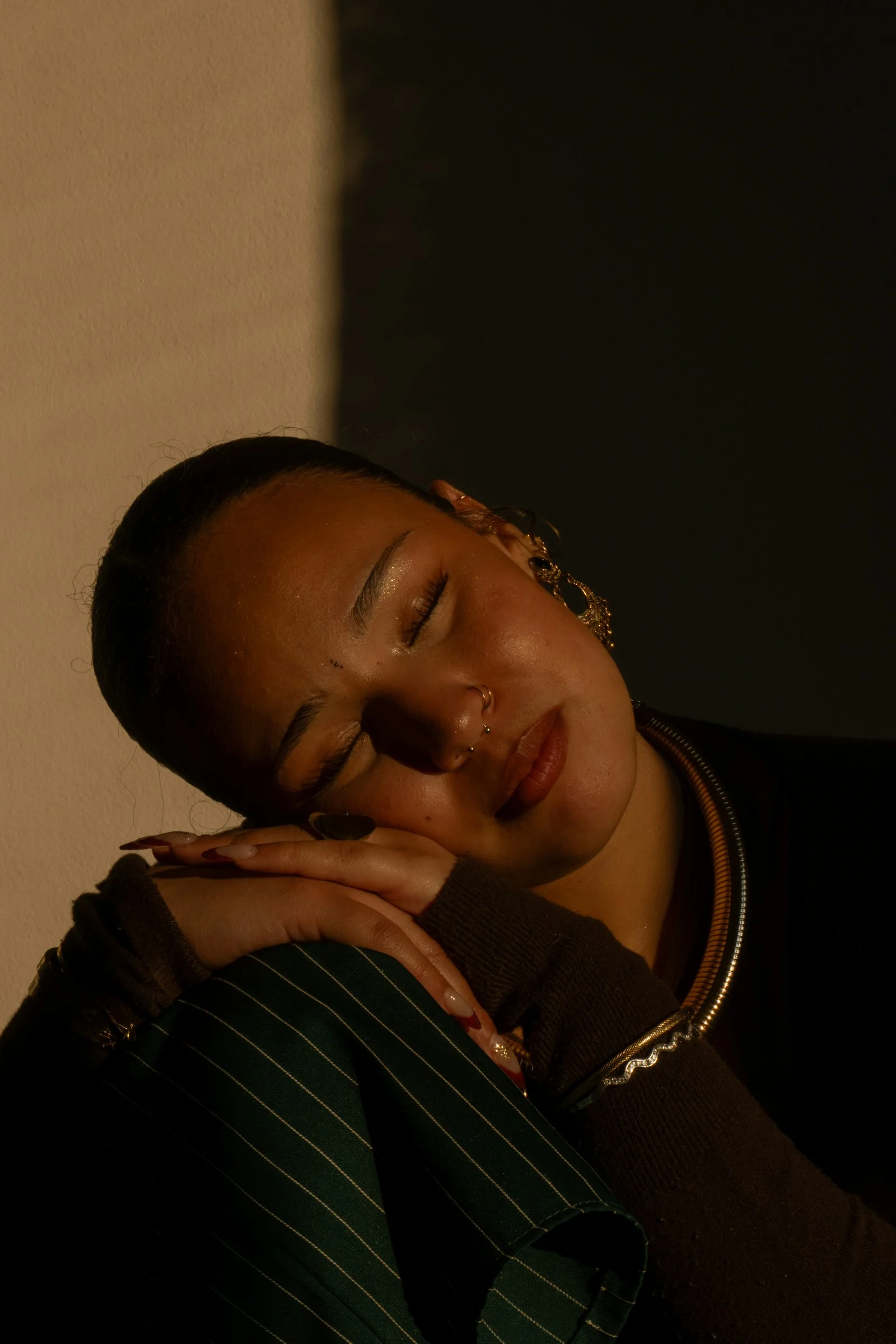 Woman rests, eyes closed, illuminated by light