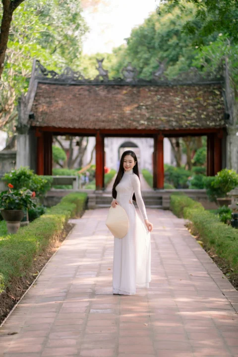 身穿白色连衣裙的女子在古寺庙前摆姿势