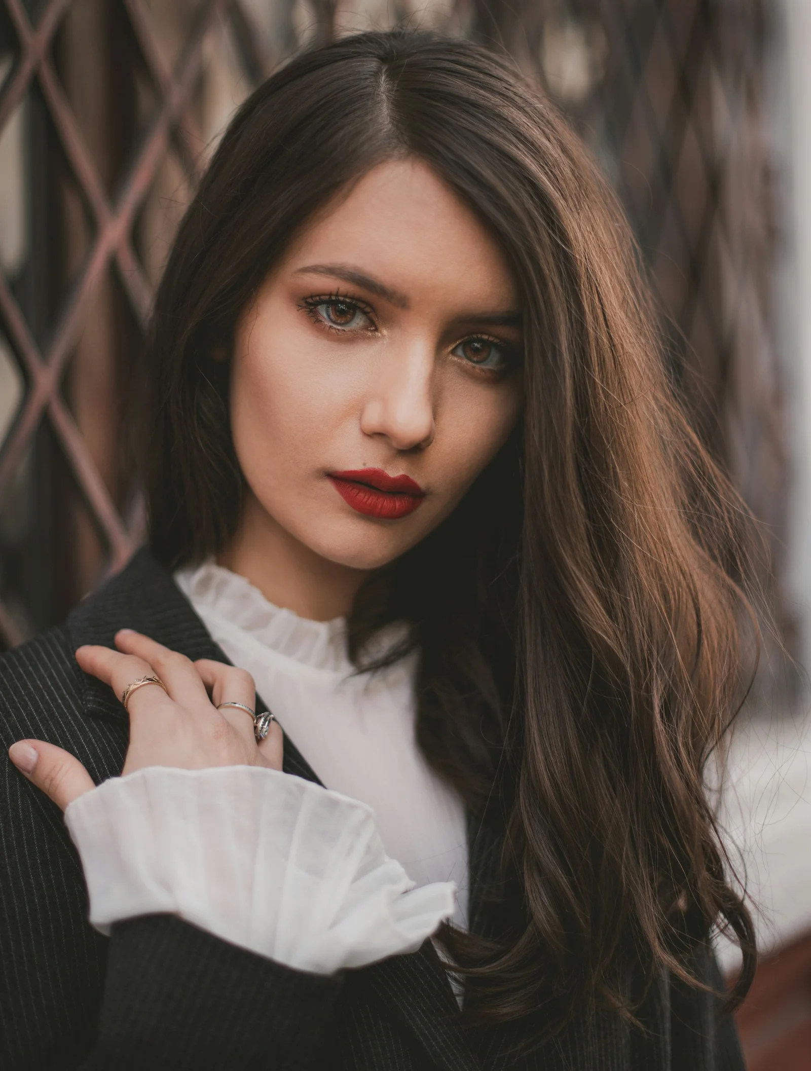a woman with long hair wearing a sweater and a ring