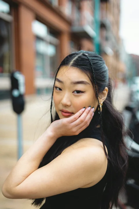 一名女子站在停車收費錶旁講手機