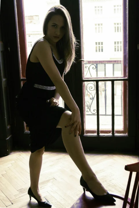 a woman in a black dress sitting on a chair