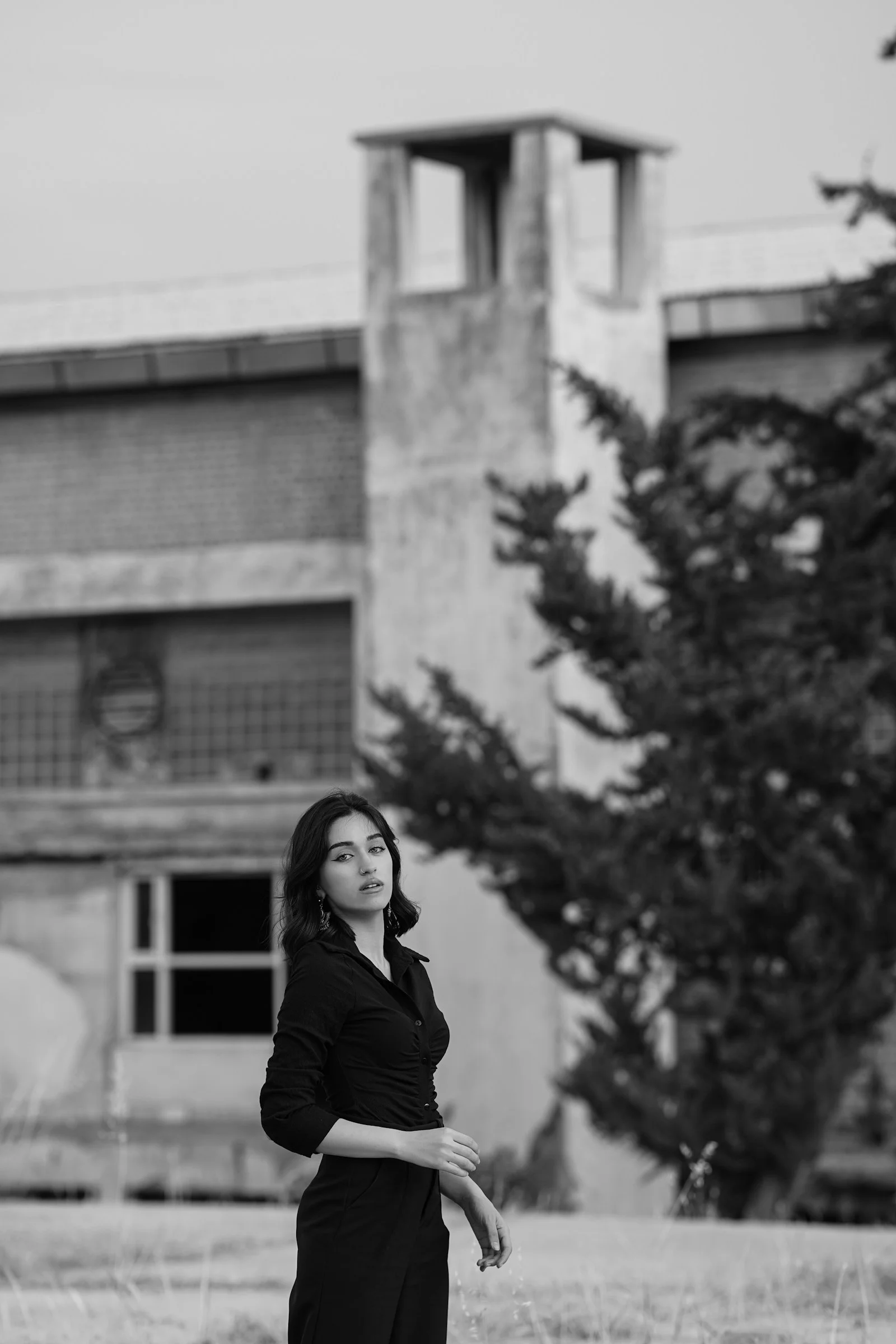 一个站在田野里、背景是建筑物的女人