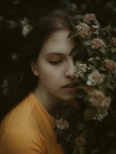 a woman is holding a bunch of flowers