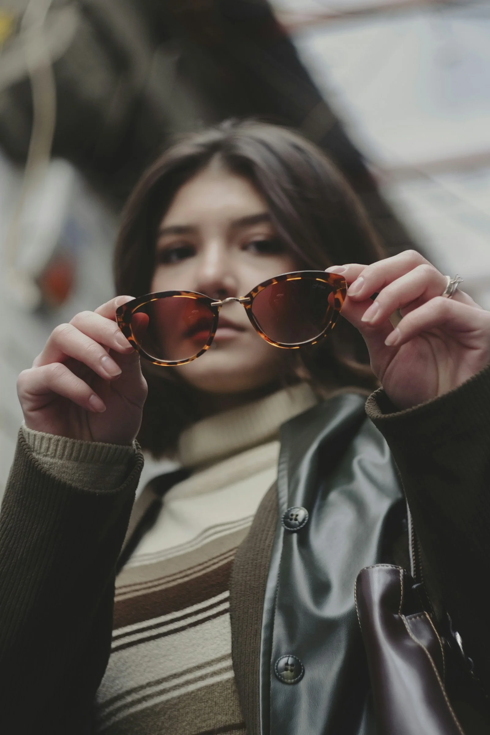a woman holding up a pair of sunglasses