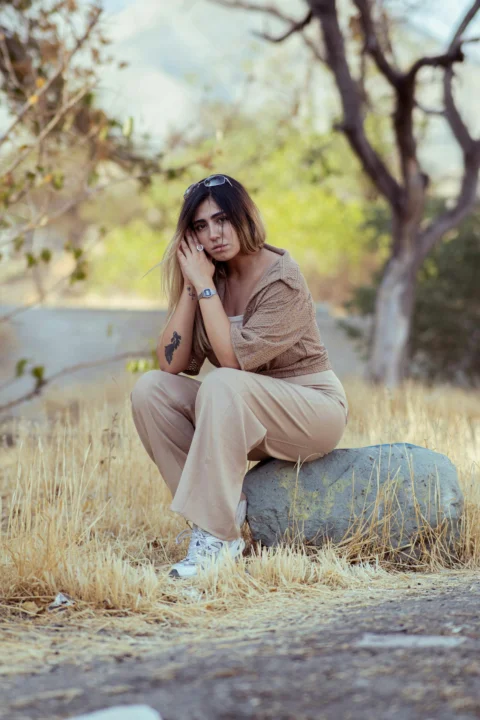 Young woman sitting on a rock outdoors