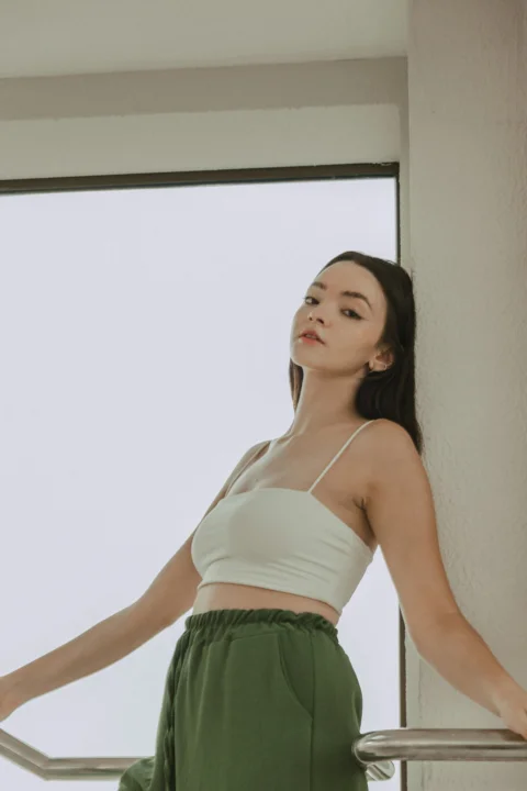 穿白色上衣和綠色褲子的女子
