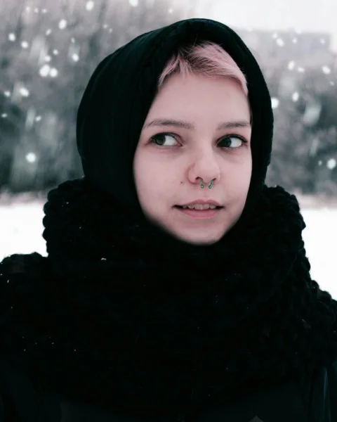 a woman with a nose piercing in the snow